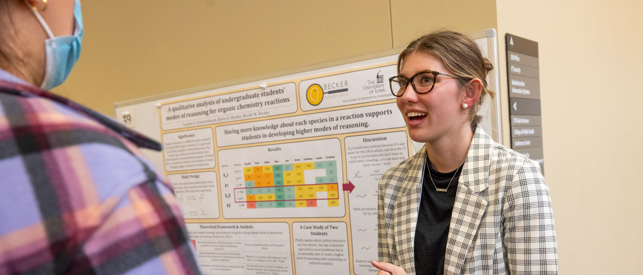 Woman presents a poster of her research