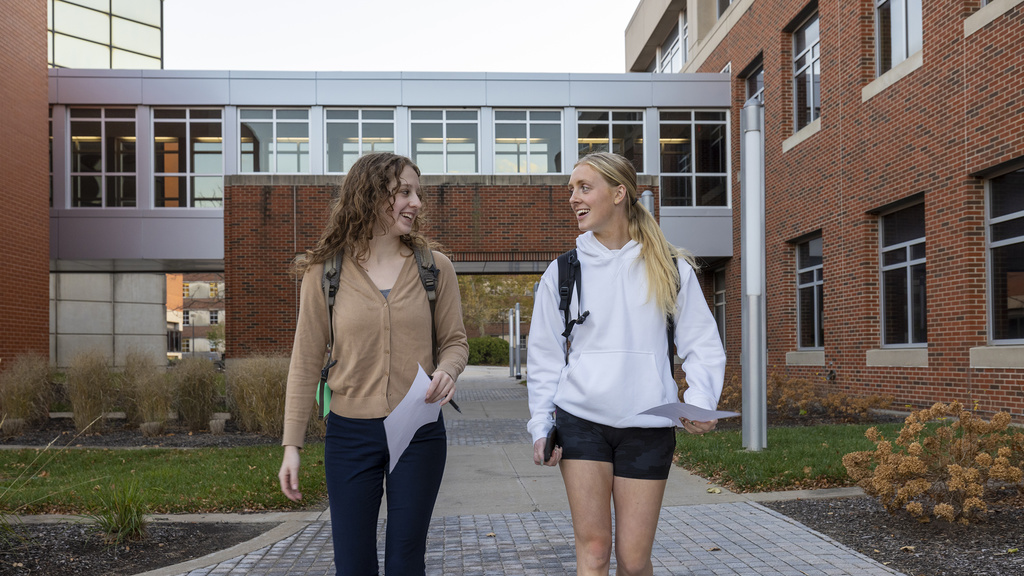 Two students talking as they walk outside